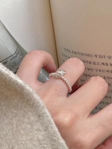Detail of 925 sterling silver beaded ring featuring dual heart charms in a minimalist style