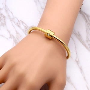 Polished gold titanium steel open bangle with diamonds shown on model wrist