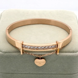 Close-up of rose gold 18k chain bracelet with engraved heart pendant and pave zircons
