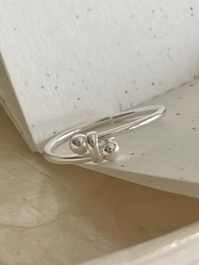 Detail of S925 sterling silver twist ring with polished beads on textured background