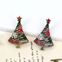 Close-up of gold and silver Christmas tree brooches with colorful rhinestones on vintage paper