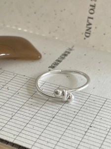 Detailed view of 925 sterling silver knotted ring with round bead accents and open band