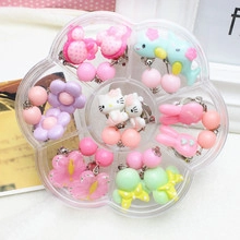 Detail of 7 pairs of colorful cartoon clip-on earrings for kids in a petal-shaped box