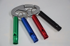 Set of four colorful aluminum emergency whistles on a large grey D-ring carabiner