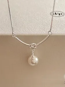 Macro detail of 925 sterling silver knotted pearl necklace on jewelry display box