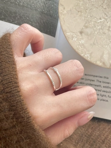 Close-up of double-layer silver ring with zircon stones on a person's hand