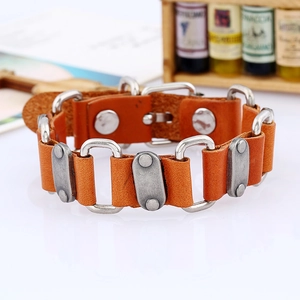 Close-up of orange-brown leather punk bracelet with silver metal rings and buckle