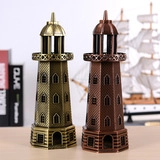 Dettaglio di ornamenti a forma di faro in bronzo e rame su scrivania in legno