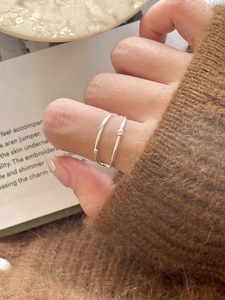 Detail of silver double-layered ring with small beads worn against a knit sweater