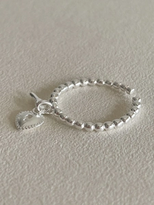 Close-up of 925 sterling silver beaded ring featuring a heart-shaped keyhole charm pendant
