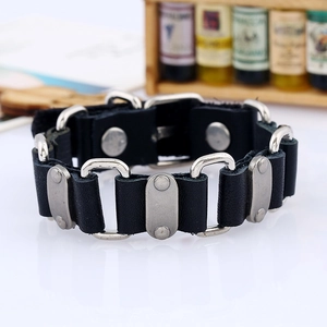 Macro shot of punk black leather bracelet with metal links and rivets on a wooden background
