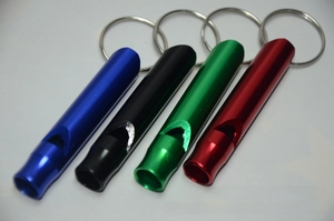 Close-up of durable aluminum survival whistles in blue, black, green and red colors