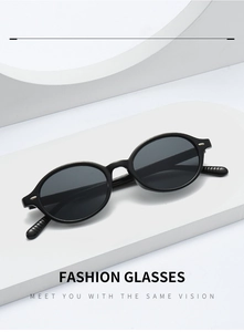 Detail of black oval sunglasses with silver rivets on a white geometric display stand