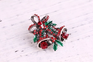 Close-up of a festive Christmas double bell brooch with red and green enamel on wood