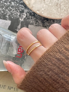 Detail of minimalist 925 silver gold double layer ring with zircon on a model hand