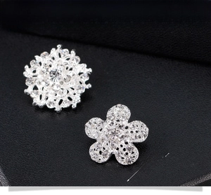 Détail de broches fleurs argentées de 2,2 cm avec cristaux sur cuir noir texturé