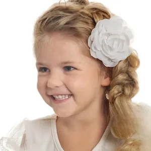 Detail of white chiffon flower hair clip worn by a young girl for wedding occasions