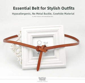 Detail of a brown leather thin belt with a knot-style metal-free buckle on a white frame