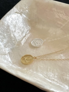 Detail of 925 silver swallow and star relief pendants in gold and silver finishes