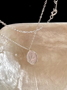 Macro shot of 925 silver swallow bird relief on oval pendant with link chain