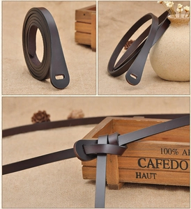 Detail shots of a dark brown thin leather waist belt with knot styling and minimalist look