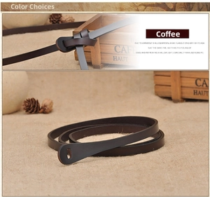 Detail of coffee brown slim leather belt tied in a knot on rustic linen background