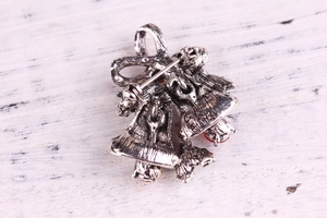 Macro view of Christmas bell brooch back side with pin buckle and rhinestone detail
