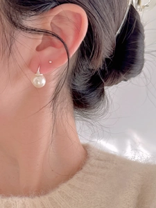 Close-up of minimalist 925 sterling silver hoop earring with white freshwater pearl detail