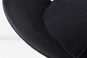 Close-up of black twill fabric texture and parallel stitching on baseball cap brim