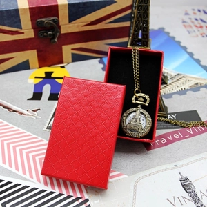 Detail of vintage bronze pocket watch with Eiffel Tower engraving and red jewelry gift box