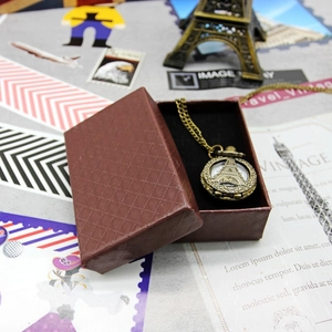 Vintage bronze Eiffel Tower pocket watch necklace displayed with brown diamond pattern gift box