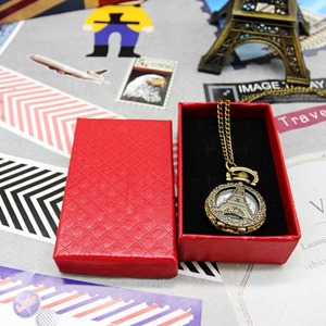 Vintage bronze Eiffel Tower pocket watch necklace showcased in a red diamond pattern gift box