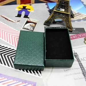 Detail of dark green jewelry box with black velvet insert and vintage background