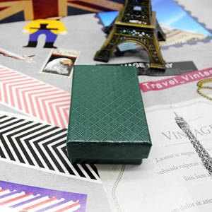 Detail of dark green jewelry box with diamond texture and vintage travel props