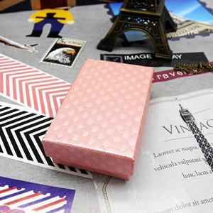 Detailed close-up of a pink textured jewelry box with diamond pattern on vintage background