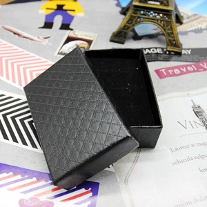 Close-up of a black diamond-textured jewelry gift box with an elegant lift-off lid