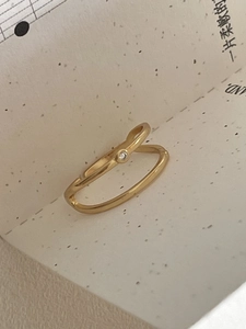 Detail view of a double-layered gold ring featuring a sparkling zircon stone minimalist design