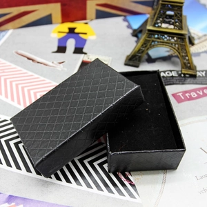 Detail of black rectangular jewelry box featuring a diamond textured finish and velvet pad