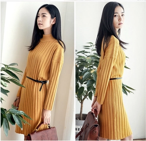 Detail of a thin black belt accessory styled on a yellow knit dress with vertical stripes