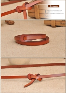 Detail of brown leather belt showing flexible texture and vintage wooden storage box