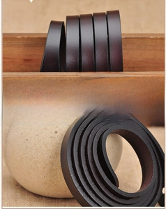 Detail of dark brown leather belt featuring premium edge finishing and smooth texture