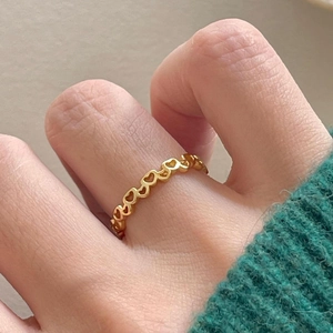 Minimalist 925 sterling silver heart ring in golden finish on finger with green sweater