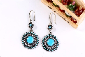 Detail of bohemian sunflower earrings with turquoise stone and antique silver finish