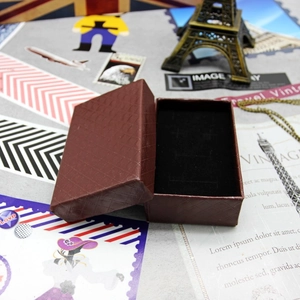 Macro shot of a vintage brown lattice-pattern jewelry box with a black foam insert