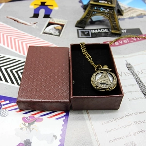 Detail shot of a bronze vintage Eiffel Tower pocket watch necklace with its gift box
