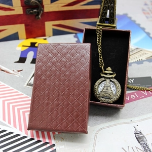 Detail of vintage bronze pocket watch with Eiffel Tower carving and brown diamond pattern box