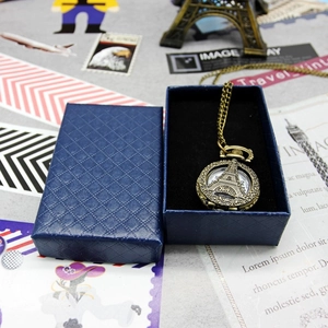 Vintage bronze pocket watch with Eiffel Tower relief displayed in a blue gift box