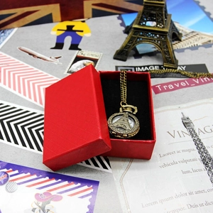Close-up of vintage bronze pocket watch necklace and red lychee grain gift box