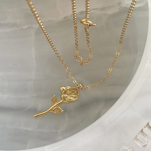 Elegant 925 sterling silver golden rose pendant necklace on a white stone background