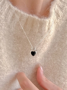 Close-up of a 925 silver heart necklace with black agate and toggle clasp on a sweater